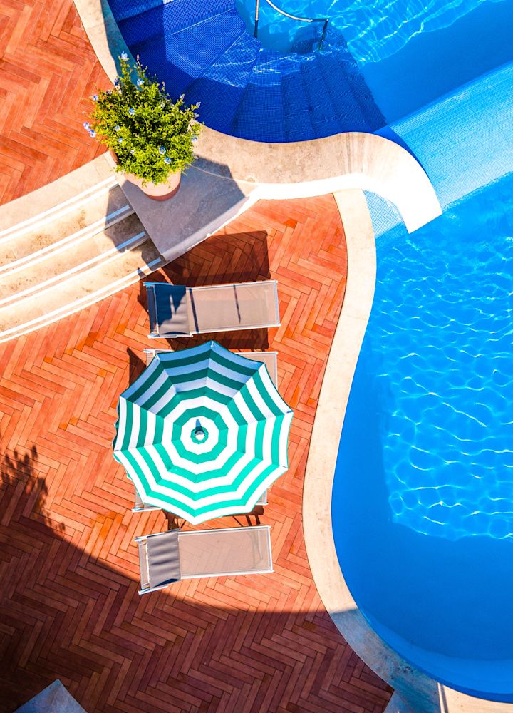 Outdoor Pool Area with Umbrella and Lounge Chairs