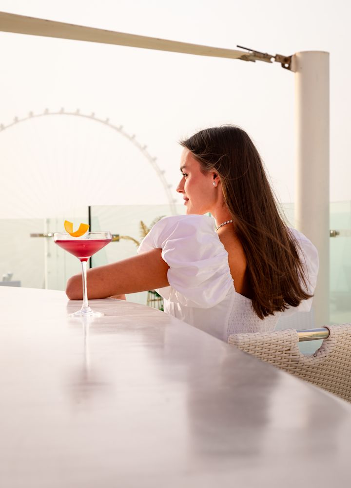 Femme buvant un verre au Pure Sky Lounge