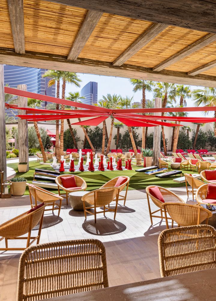 coin détente couvert près de la piscine extérieure avec un grand jeu d'échecs en arrière-plan