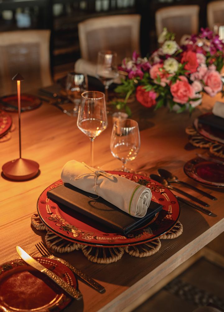 configuração de mesa de restaurante com louça para jantar, taças de vinho e flores frescas
