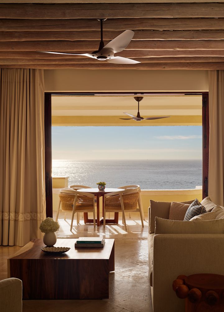 Área de estar da suíte com lareira e vista para o mar do terraço