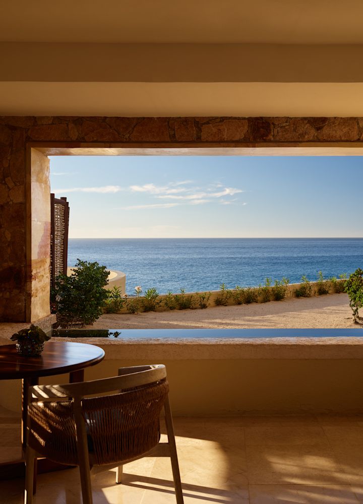 Vista para o mar da área de estar de um quarto com piscina