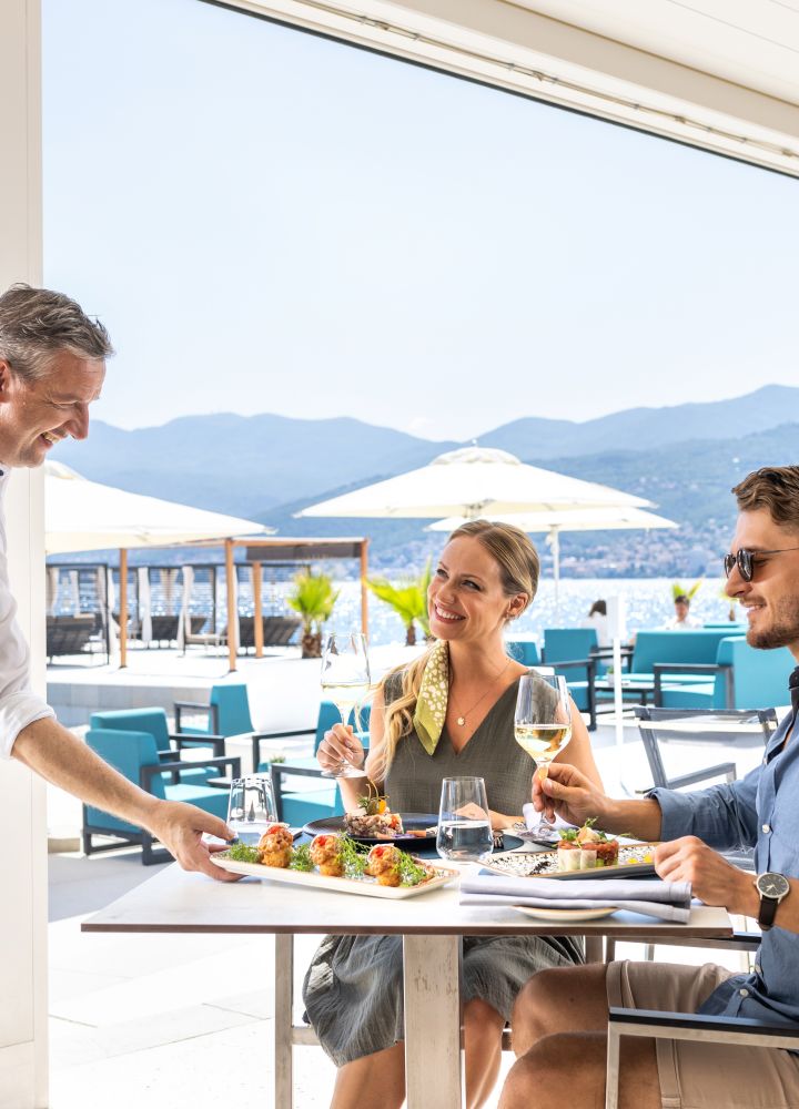 Man and woman being served food by waiting staff
