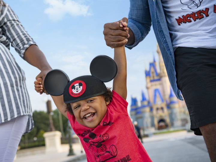 Child with Mickey Mouse ears near Enchanted Castle