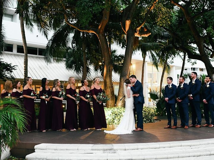 Groom and Bride Kiss with Attendants Nearby in Outdoor Wedding at Hilton Fort Lauderdale