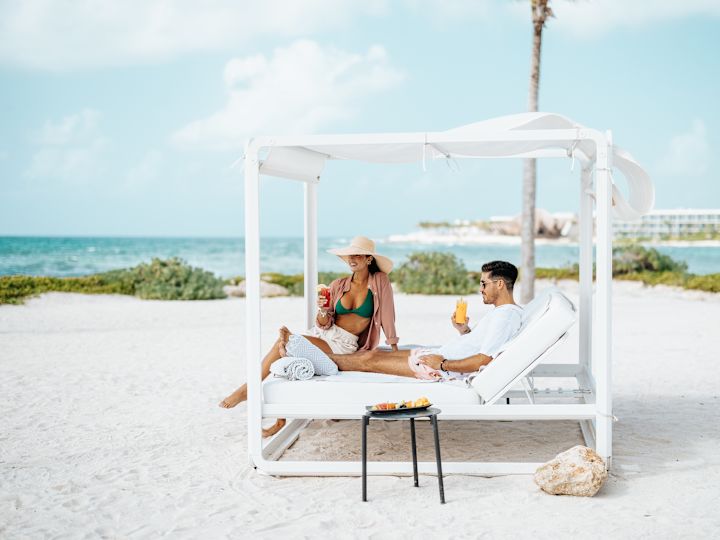Couple enjoying drinks on sun lounger