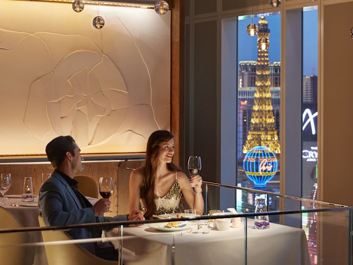 Couple prenant un verre de vin dans la salle à manger avec vue sur le Strip