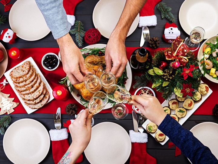 christmas table setting with people toasting