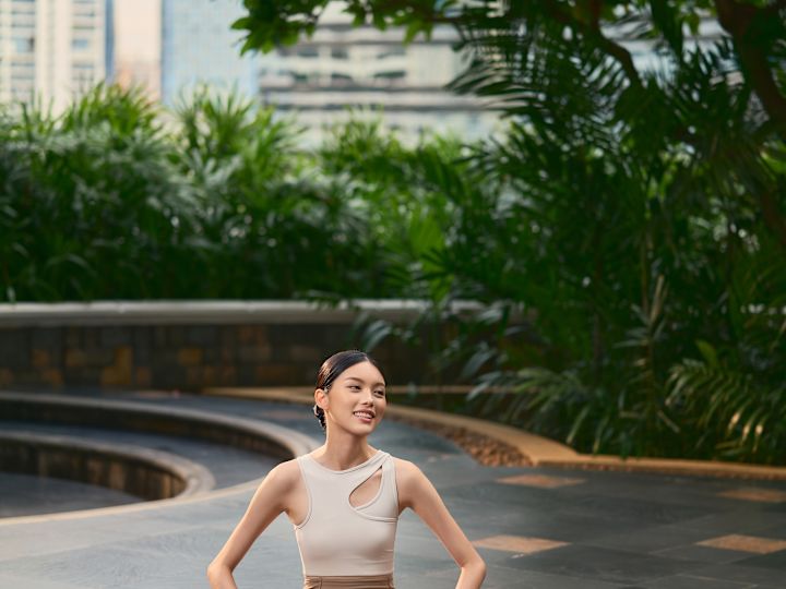 Femeie exersând yoga pe un covoraș în aer liber