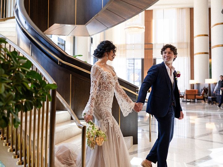 Bride and Groom  Holding Hands in Lobby Stairs on Their Wedding Day