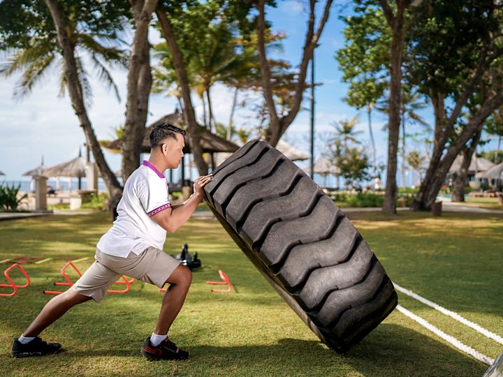 Seorang pria yang berpartisipasi dalam bootcamp sedang berolahraga di luar ruangan