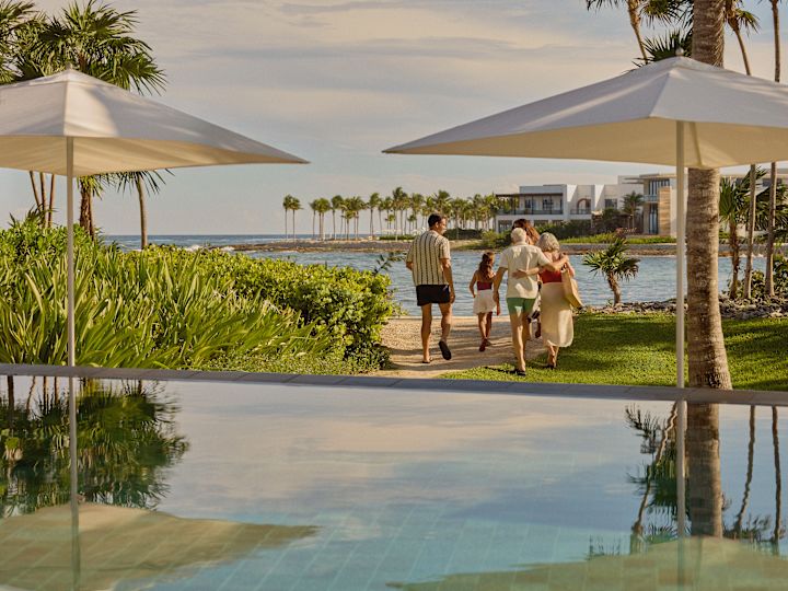 Family consisting of grandfather, grandmother, father, mother and daughter heading to the beach