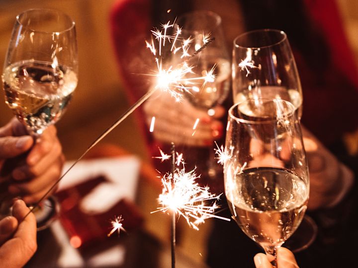 Gruppo di persone che tiene in mano bicchieri e scintille