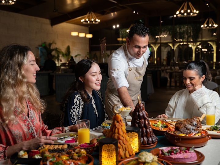 Číšník podává jídlo na stůl v restauraci