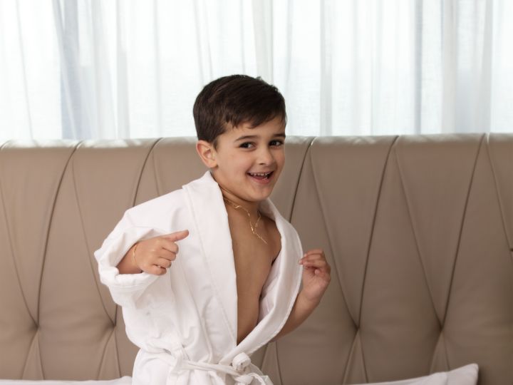 Young boy jumping on bed