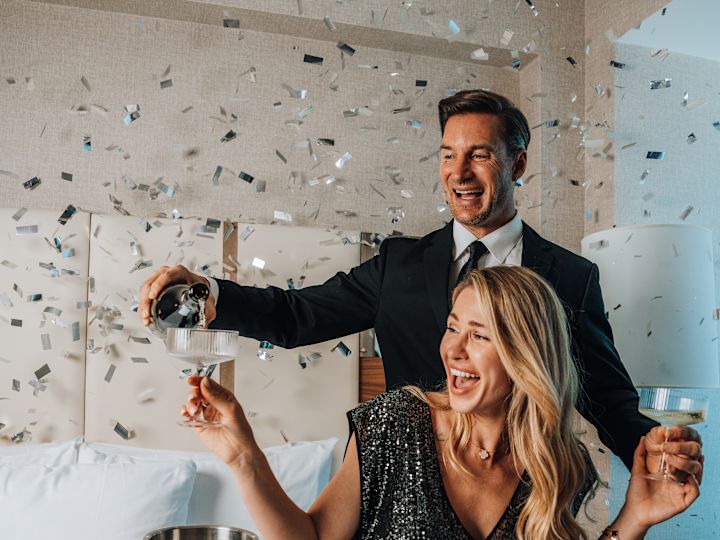 Couple Having Champagne in a Guest Room to Celebrate the Holidays