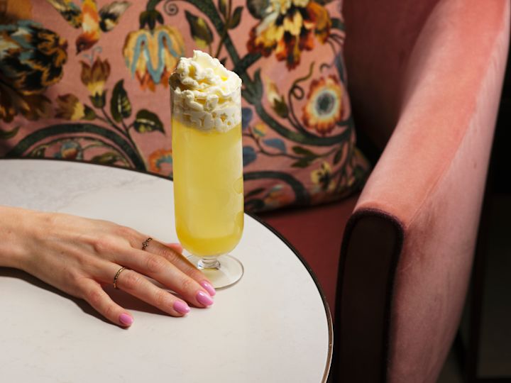 A Woman's Hand with a Drink on a Table at The Hedgerow Bar