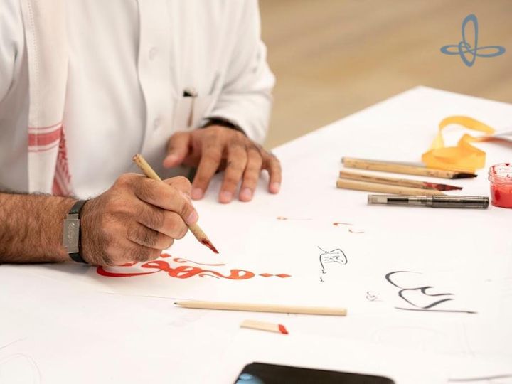 Man writing calligraphy at a hotel event.