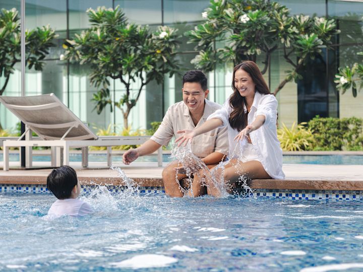 عائلة تستمتع بوقتك وتستمتع بيوم في حمام السباحة وبار سيلز بجوار حمام السباحة