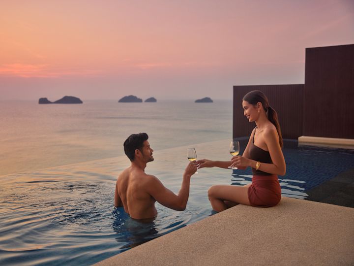 Man and woman relaxing around private pool with drinks