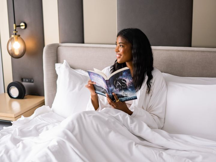 Women Reading in Guest Room Bed