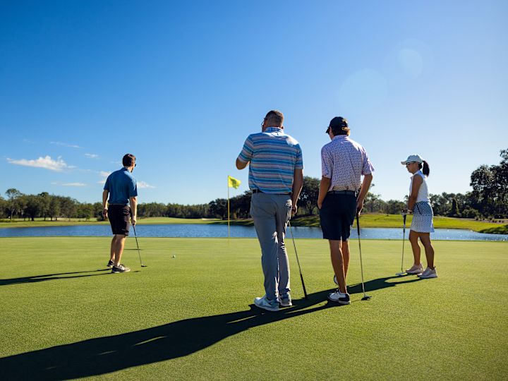 Persone che giocano a golf al Cypress Course con acqua minerale