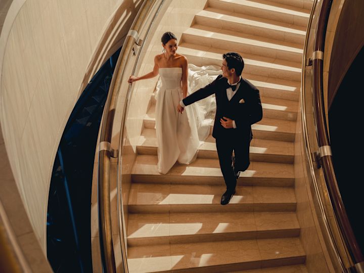 Hochzeitspaar, das eine große Treppe hinabfährt