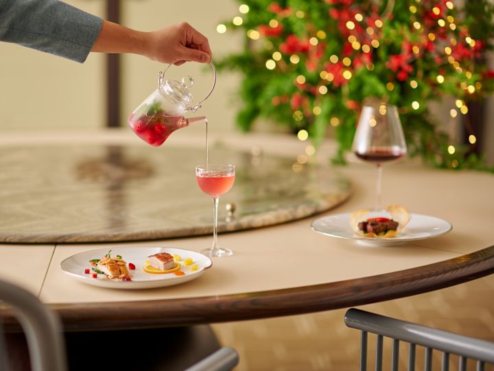 boisson rouge servie par le personnel dans un décor festif en arrière-plan