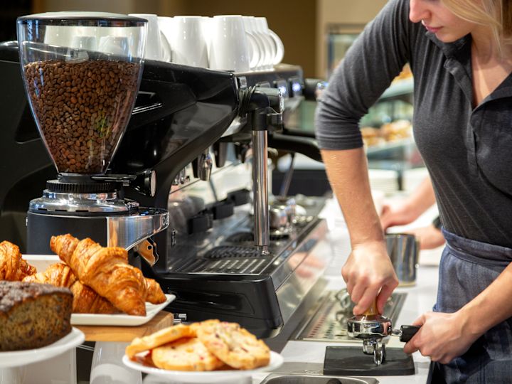 the foregrounBarista at the Pocket Café, packing coffee grounds with pastries in d.
