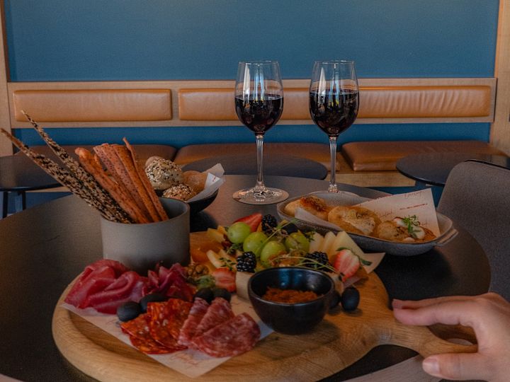 Handhalten eines Tabletts mit Speisen und Getränken auf einem Tisch im Restaurant "Overlook"