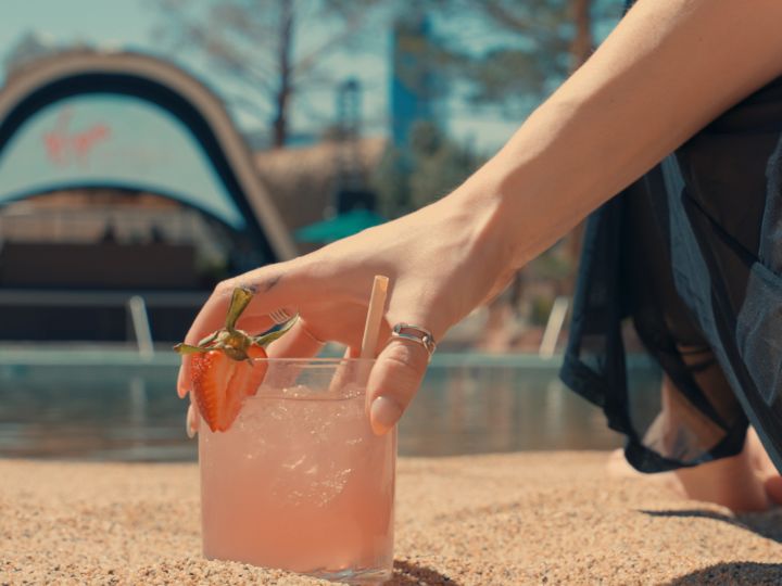 Person holding a cocktail on outdoor pool area