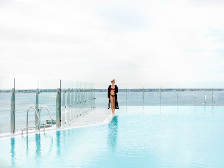 Wanita Berjalan di Sekitar Area Kolam Renang Atap