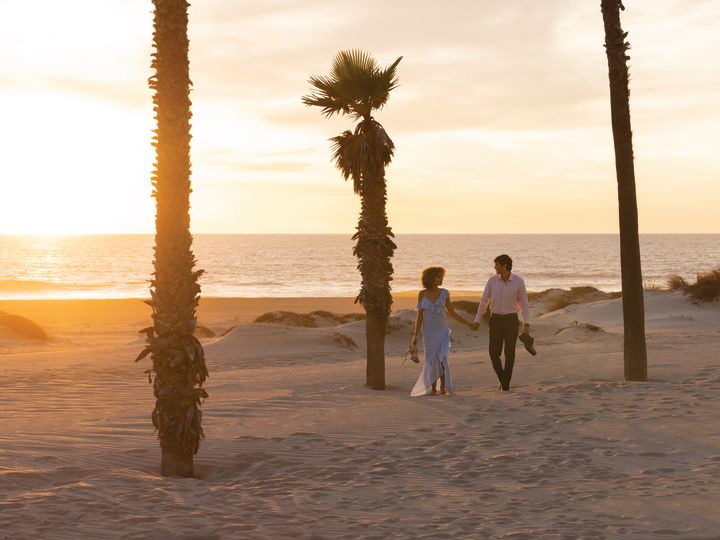 Couple Enjoying a Walk on the Beach at Sunset