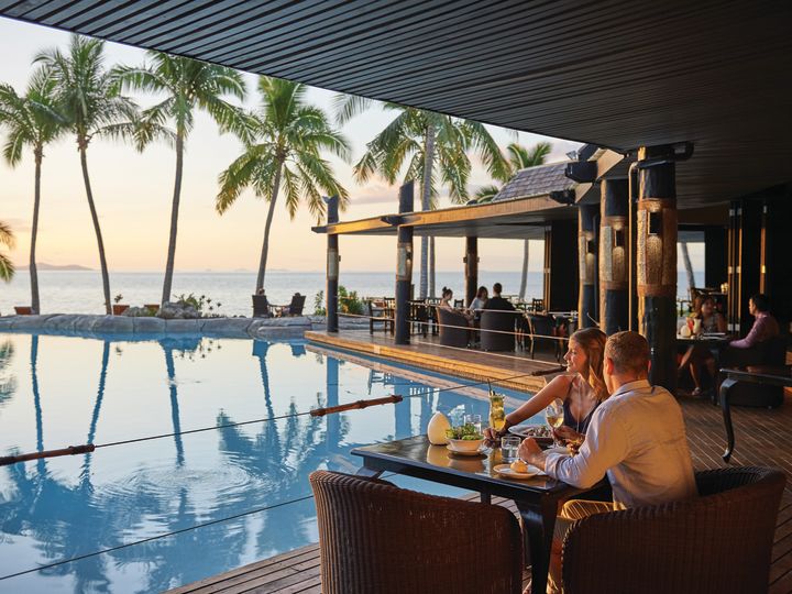 People Dining Poolside at Vulani Restaurant With Sunset View