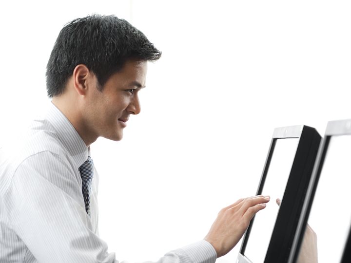 Businessman Sitting at Desk Conducting Business on a Computer