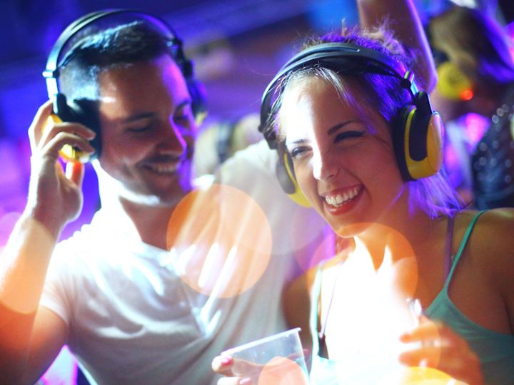 Couple Smiling and Drinking while Listening to Music with Headphones 
