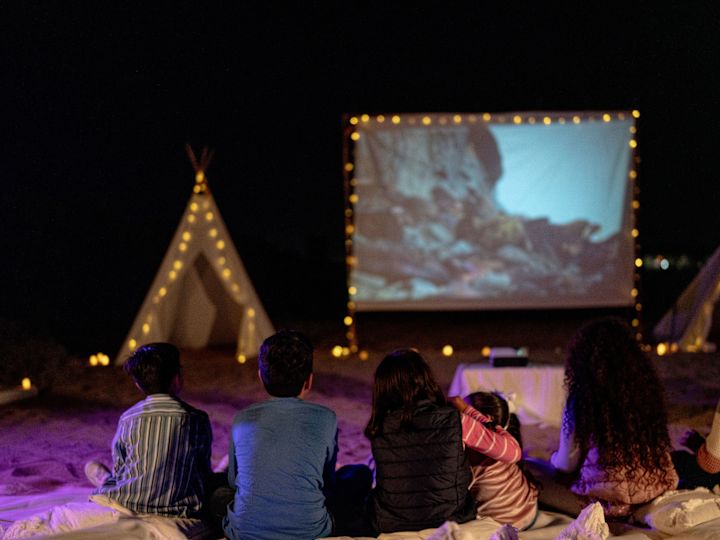 People Watching a Movie Outdoors at Night