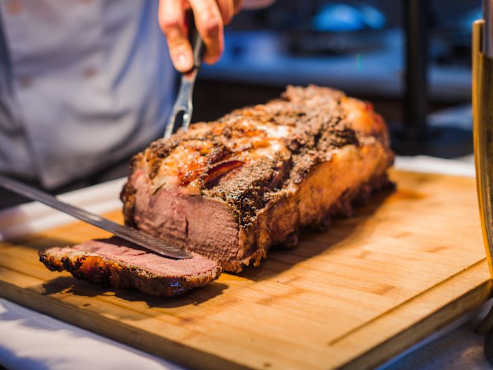 Person Cutting Meat at Garden Terrace Restaurant