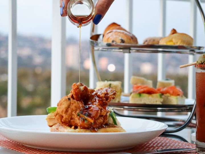 Sauce being poured on meal at an outside table.