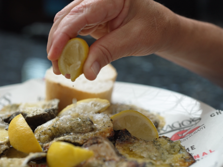 一位女士在给盘中的生蚝加柠檬汁