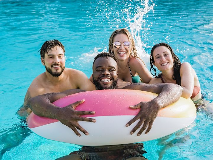 guests in the pool with a pink and white floatie