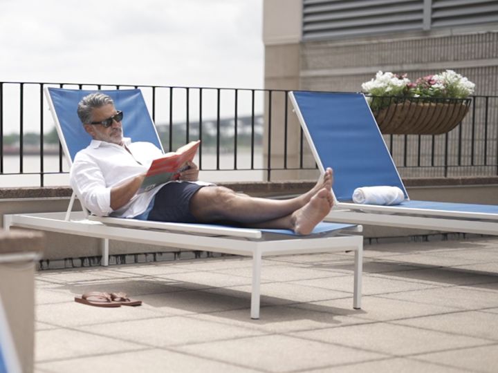 guest lounging by the outdoor pool