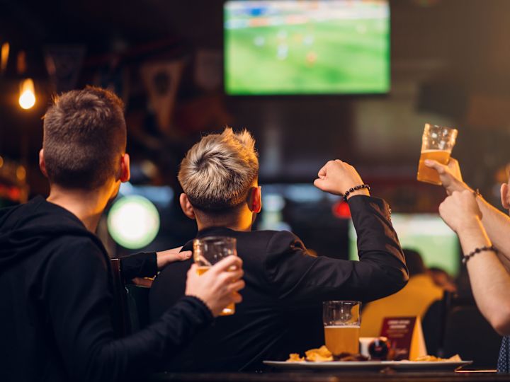 a Group of Friends Drinking Beer while Watching a Game at a Sports Bar