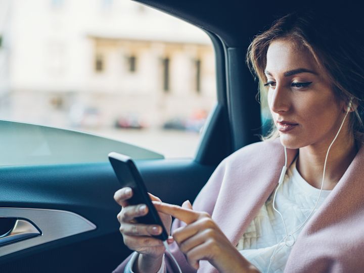 Woman in a Car Looking at Her Phone