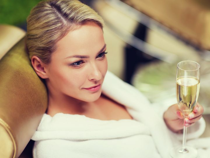 Woman relaxing with a glass of champagne in spa