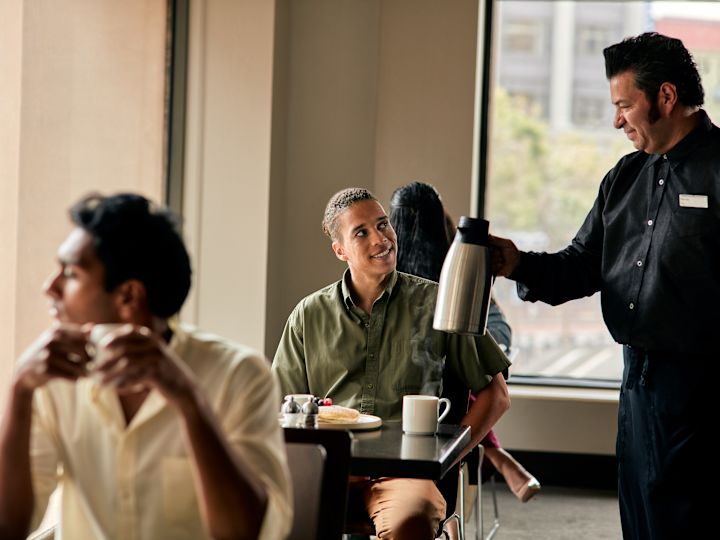 Waiter is serving coffee to a guest at Cable 55 restaurant
