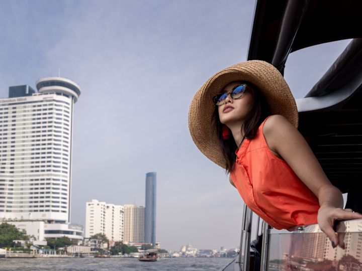 person in hat leaning over balcony