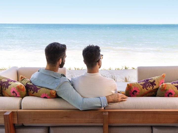 ผู้ชายสองคนนั่งข้างกันและมองดูมหาสมุทร