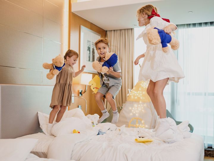 Enfants sautant sur le lit avec des ours Hilton à thème