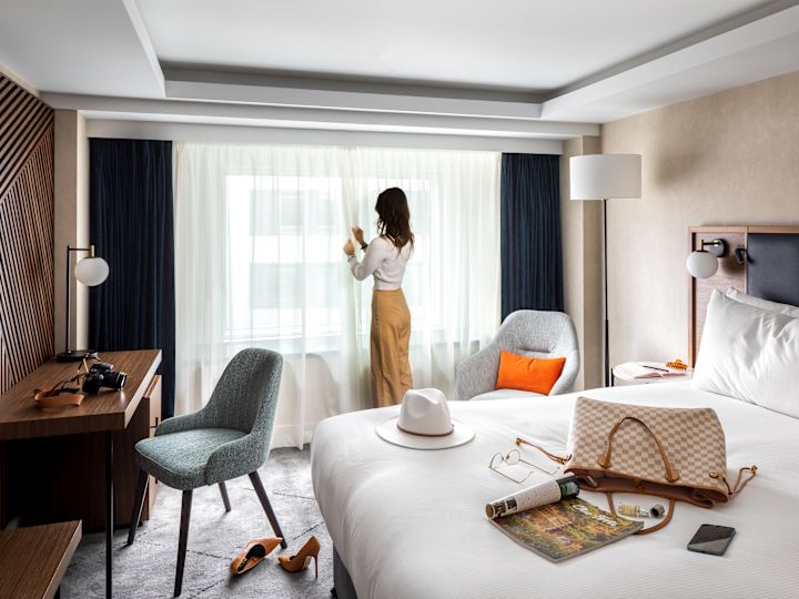 Deluxe Bedroom with person pulling curtains